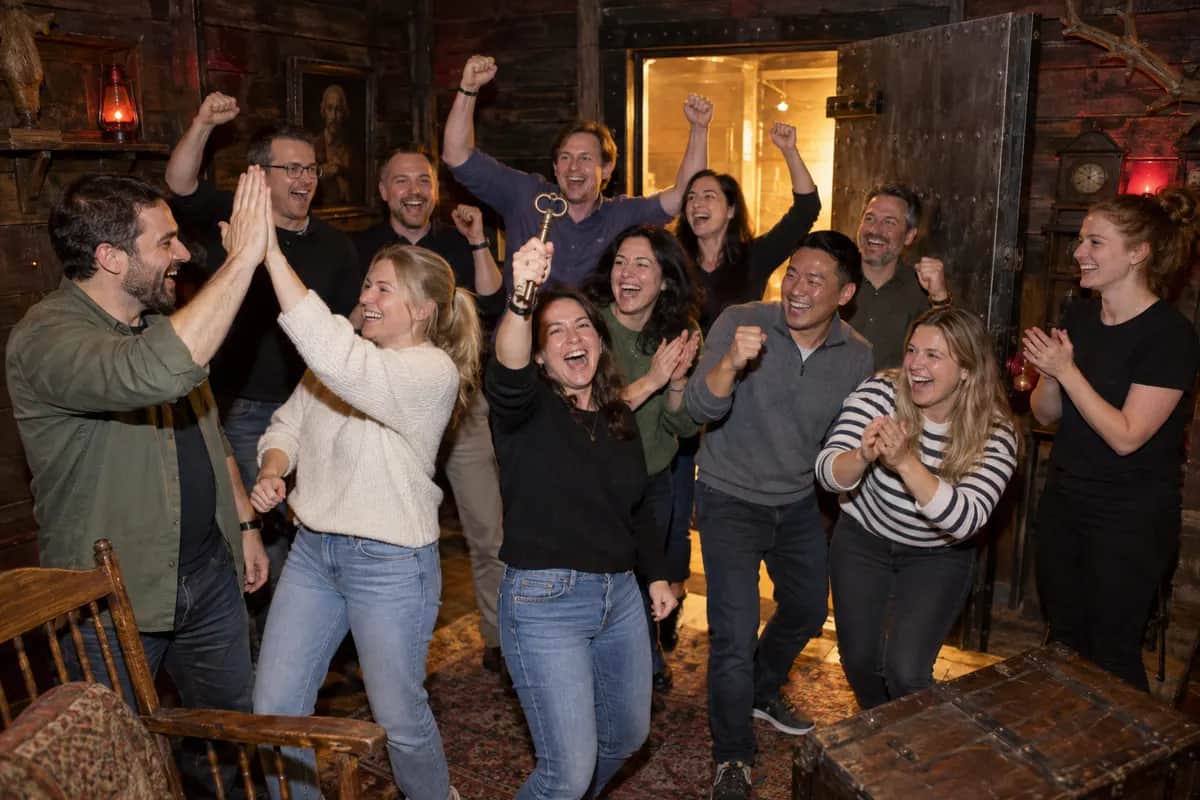 Colleagues cheering together after a team game in the escape room